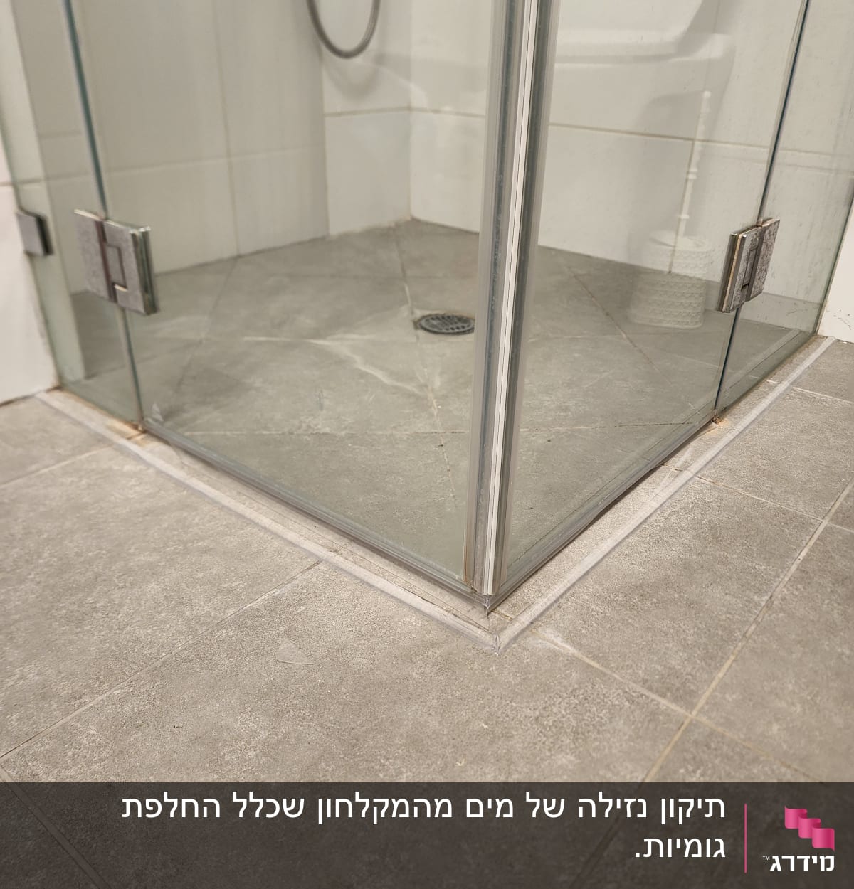 מקלחון זכוכית עם רצפת אריחים אפורה